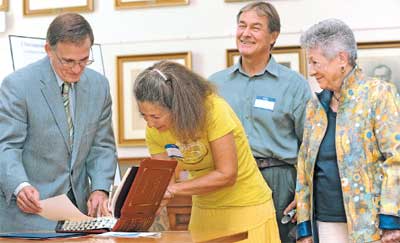 Clerk of the Court Robert Duckworth has Maria Price- Nowakowski, with Martin Nowakowski and Aphrodite Poulos, sign the register declaring their Willow Oak Flower and Herb Farm in Severn a protected property.